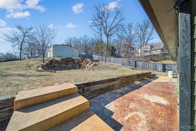 view of yard featuring a storage unit, a patio area, a fenced backyard, and an outdoor structure