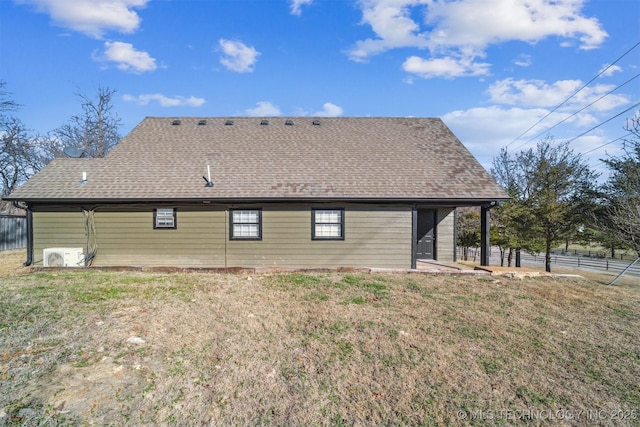 rear view of property with ac unit, a shingled roof, fence, and a lawn