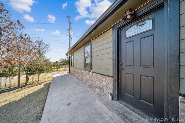 view of exterior entry featuring fence