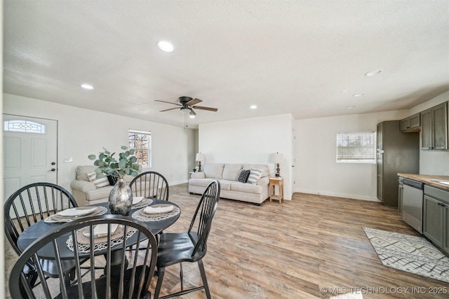 dining space featuring light wood finished floors, baseboards, and recessed lighting