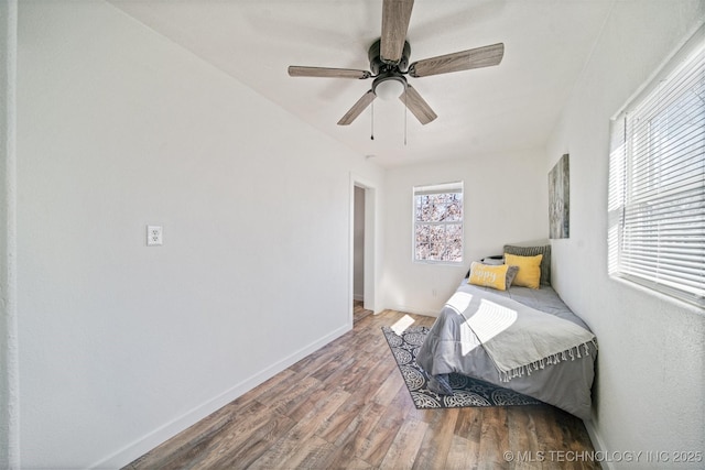 bedroom featuring ceiling fan, wood finished floors, and baseboards