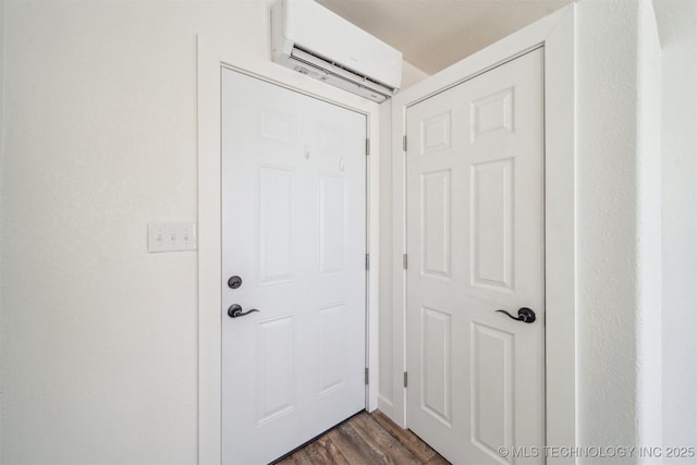 entryway with dark wood-style floors and an AC wall unit