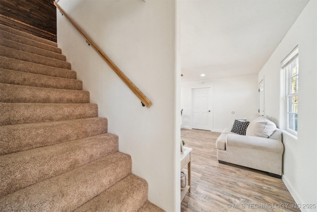 staircase featuring baseboards and wood finished floors