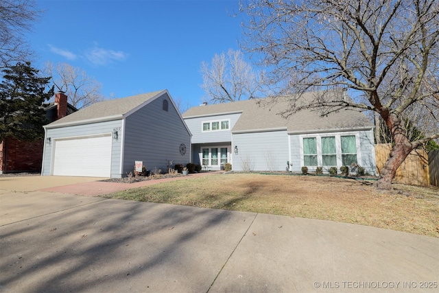 view of front of home with a front lawn, concrete driveway, and an attached garage