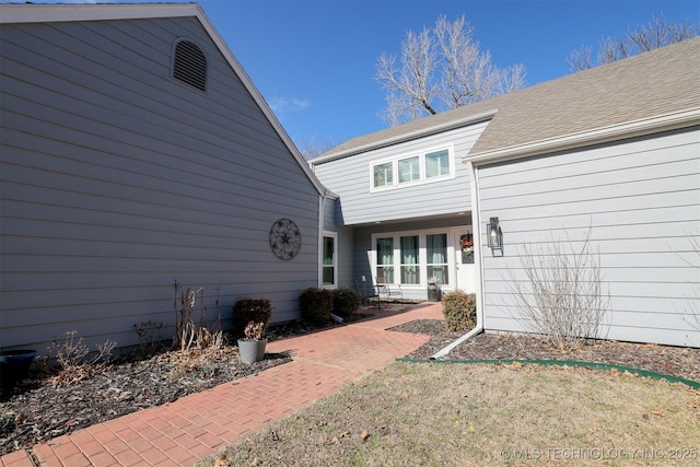 rear view of property featuring a shingled roof