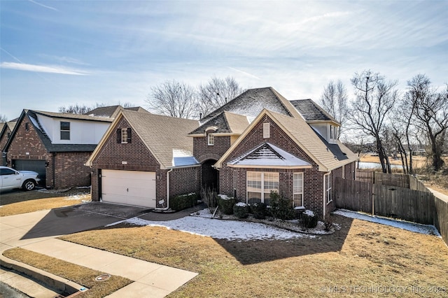 view of front of house with concrete driveway, brick siding, and fence