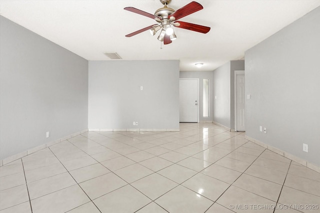 unfurnished room featuring light tile patterned floors, baseboards, visible vents, and a ceiling fan