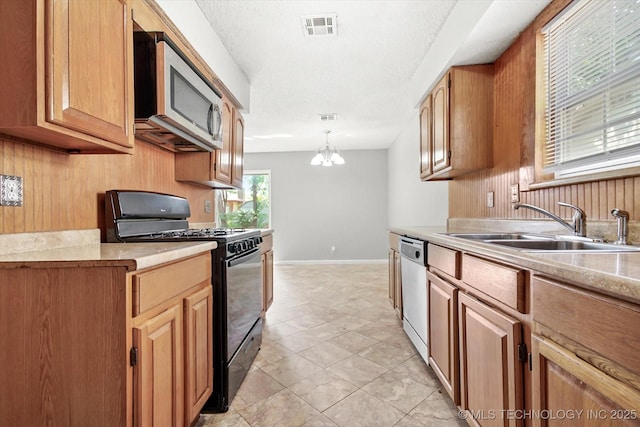 kitchen with light countertops, appliances with stainless steel finishes, a sink, and visible vents