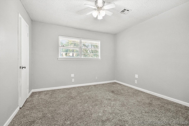 spare room with carpet floors, baseboards, visible vents, and a textured ceiling