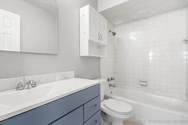 bathroom with toilet, vanity, a textured ceiling, and shower / bathtub combination