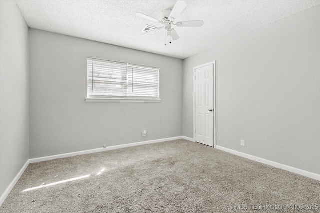 spare room with visible vents, carpet floors, a textured ceiling, and a ceiling fan