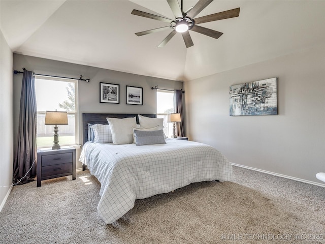 carpeted bedroom with lofted ceiling, multiple windows, and baseboards