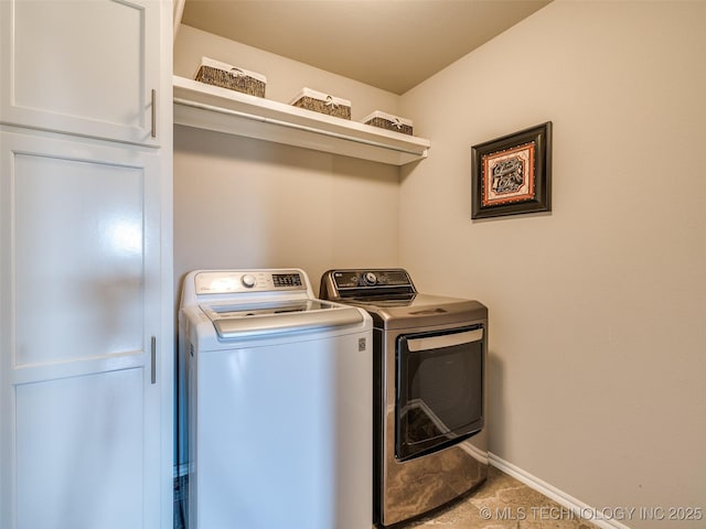 laundry room featuring baseboards, cabinet space, and washing machine and clothes dryer