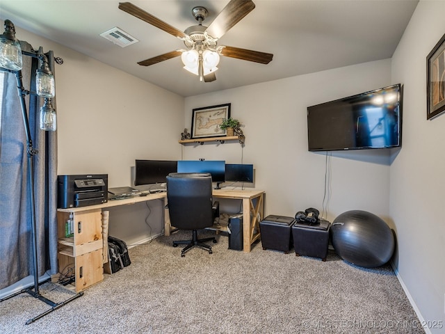 carpeted office featuring baseboards, visible vents, and a ceiling fan