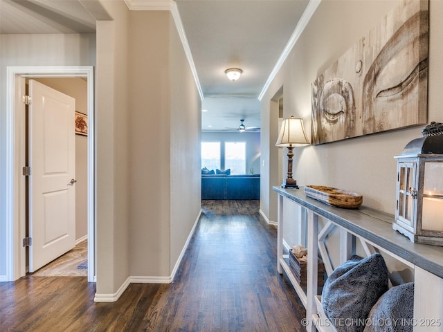 corridor featuring ornamental molding, wood finished floors, and baseboards