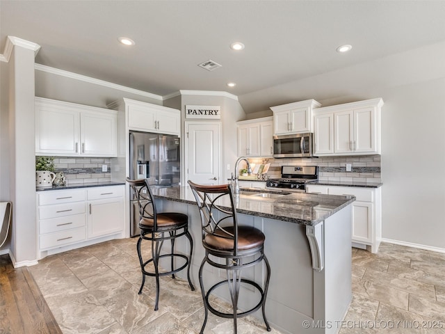 kitchen featuring white cabinetry, visible vents, stainless steel appliances, and a sink