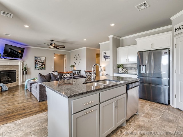 kitchen with stainless steel appliances, open floor plan, visible vents, and a sink