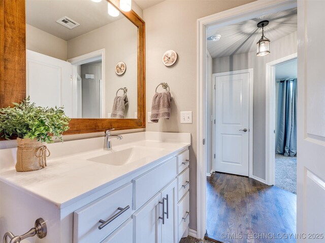 bathroom with visible vents, wood finished floors, and vanity