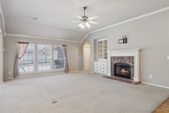 unfurnished living room featuring arched walkways, ornamental molding, a brick fireplace, and baseboards