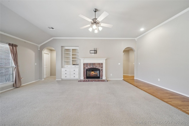 unfurnished living room with baseboards, visible vents, arched walkways, and built in features