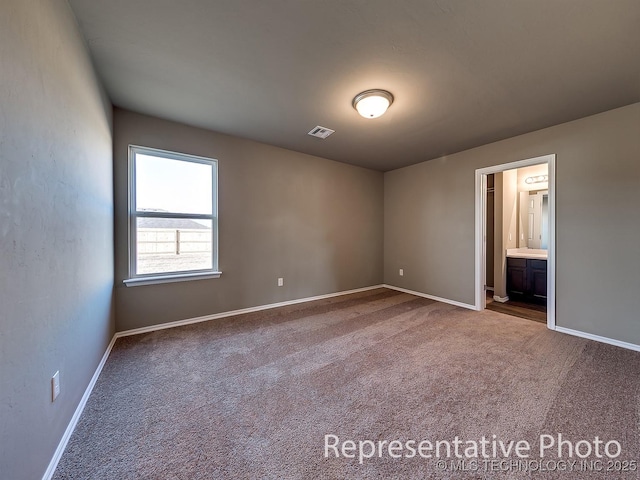 unfurnished bedroom featuring baseboards, connected bathroom, visible vents, and carpet flooring