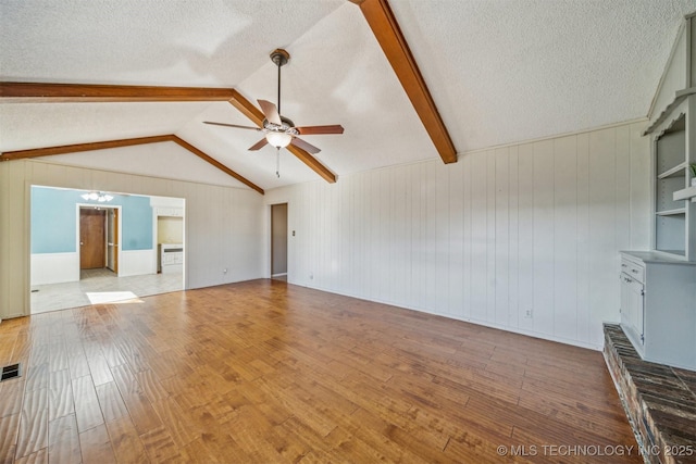 unfurnished living room with a textured ceiling, vaulted ceiling with beams, visible vents, a ceiling fan, and wood-type flooring