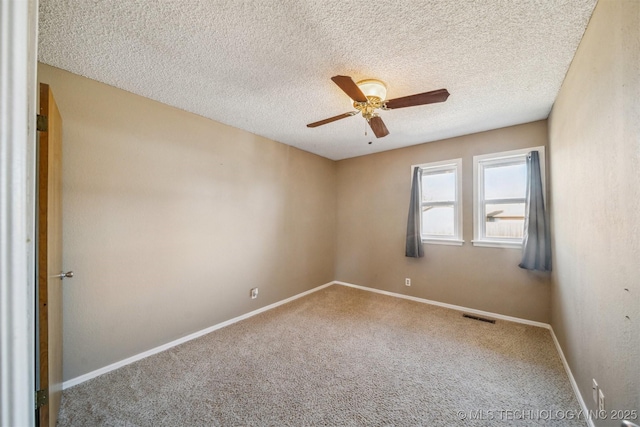 spare room with visible vents, carpet flooring, ceiling fan, a textured ceiling, and baseboards