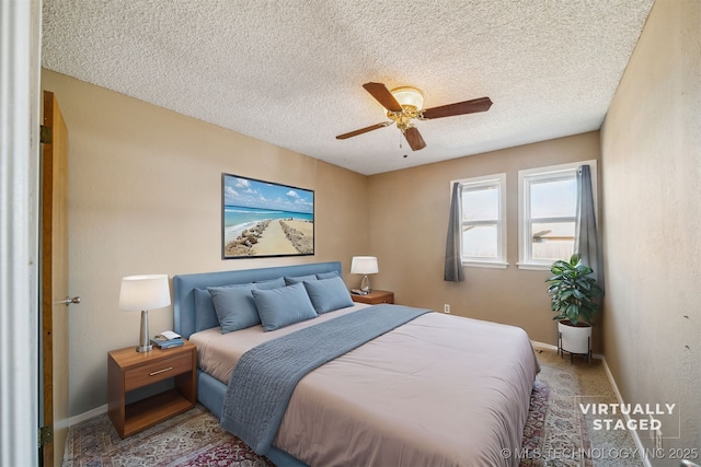 carpeted bedroom featuring a ceiling fan, a textured ceiling, and baseboards