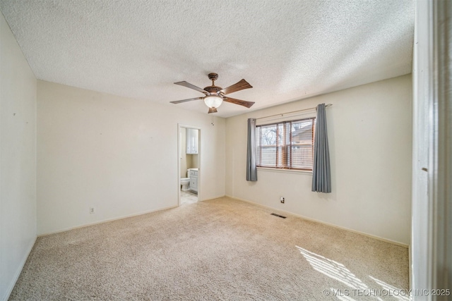 unfurnished room featuring ceiling fan, a textured ceiling, visible vents, and carpet flooring