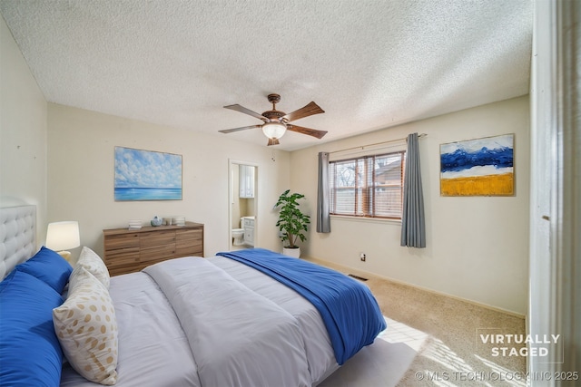 carpeted bedroom with visible vents, baseboards, ensuite bath, ceiling fan, and a textured ceiling