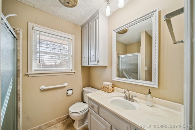 bathroom with baseboards, toilet, a textured ceiling, vanity, and a shower stall