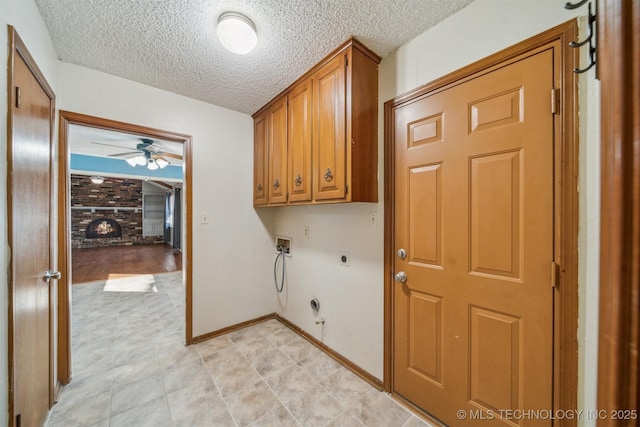 laundry area with cabinet space, ceiling fan, hookup for a washing machine, a fireplace, and electric dryer hookup