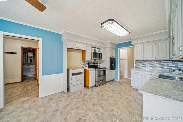 kitchen featuring a textured ceiling, a sink, ornamental molding, appliances with stainless steel finishes, and backsplash