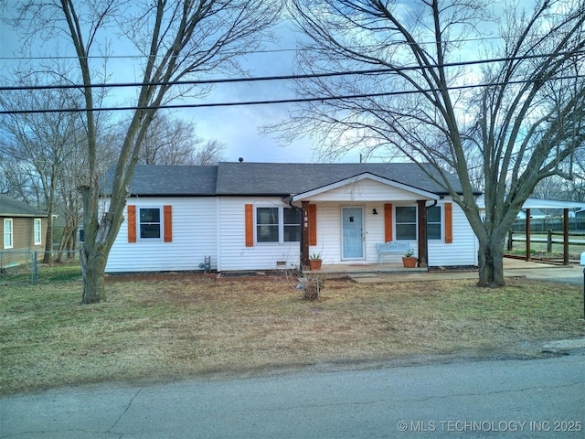 view of front facade featuring covered porch, fence, a front lawn, and roof with shingles