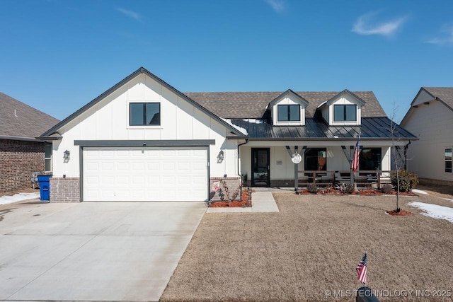 view of front of house with brick siding, a porch, concrete driveway, a standing seam roof, and metal roof