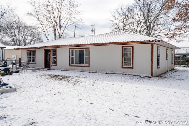 snow covered house with fence