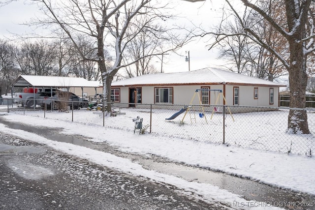 view of front of home with fence and a playground