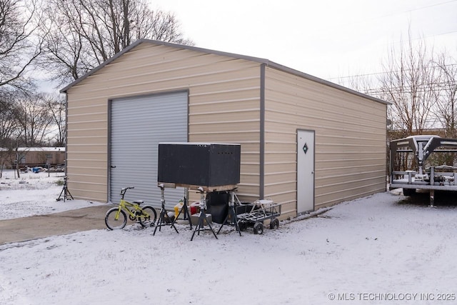 snow covered garage featuring a garage