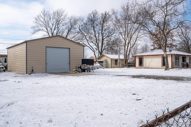 snow covered garage featuring a garage