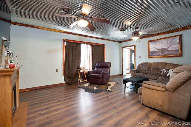 living area with wood finished floors, a ceiling fan, and baseboards