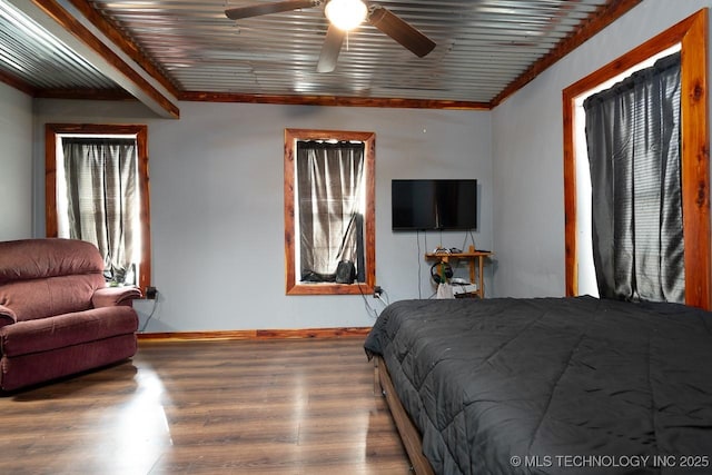 bedroom featuring a ceiling fan, crown molding, baseboards, and wood finished floors