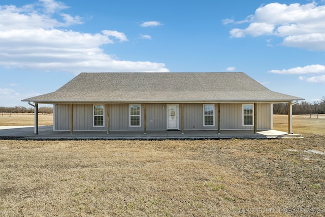 view of front of home featuring roof with shingles and a front lawn