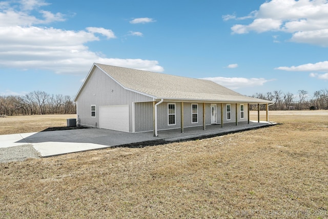 view of front of house with a garage, driveway, covered porch, cooling unit, and a front lawn