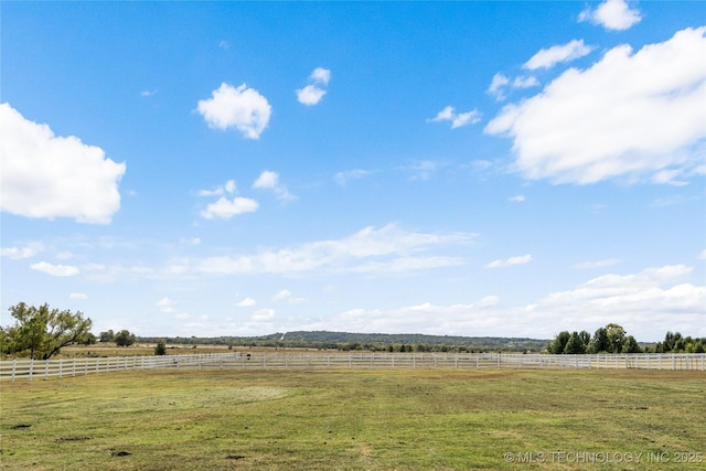 view of yard featuring a rural view and fence