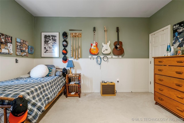 carpeted bedroom with a wainscoted wall