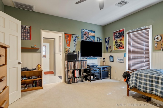 bedroom with a wainscoted wall, carpet flooring, and visible vents