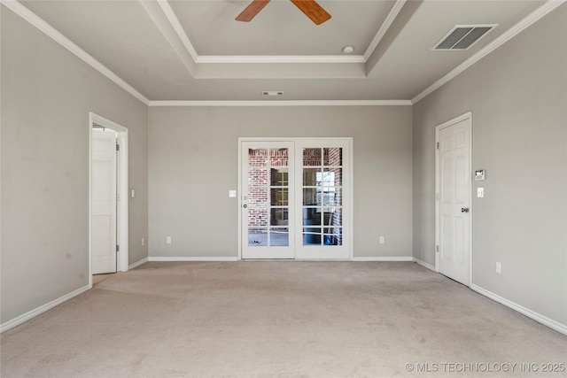 carpeted empty room with crown molding, visible vents, and a tray ceiling