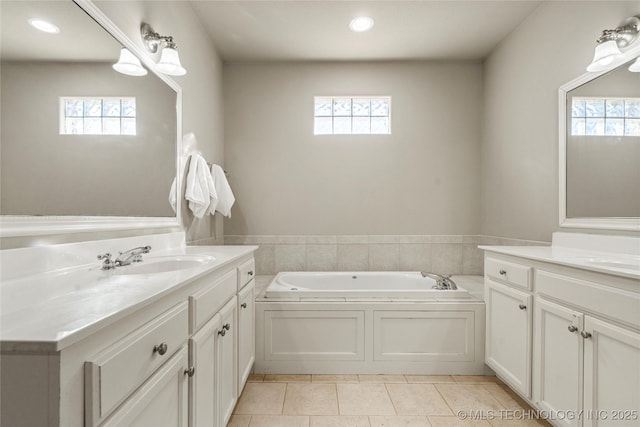 full bath featuring plenty of natural light, two vanities, and a sink