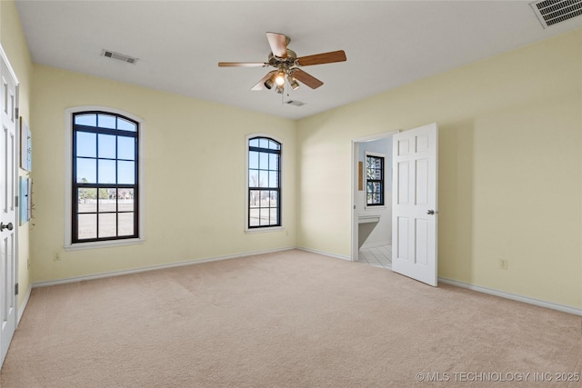 interior space featuring baseboards, visible vents, and light colored carpet