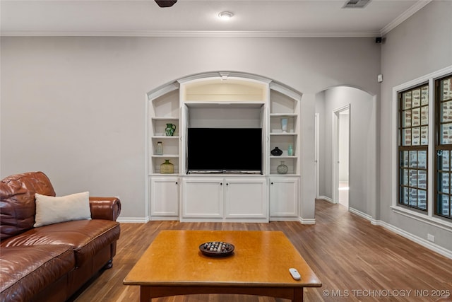 living room with arched walkways, baseboards, and wood finished floors